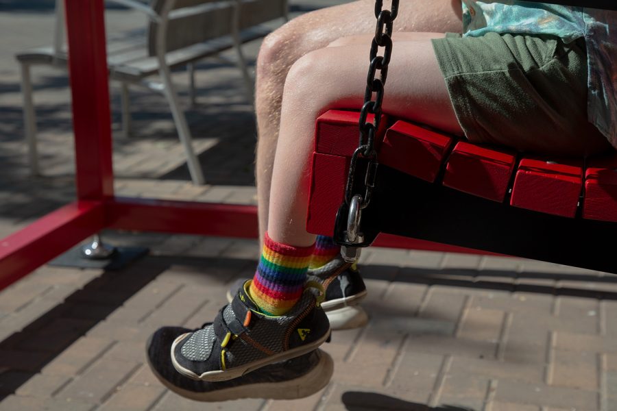 An+Iowa+City+community+member+wears+socks+with+pride+colors+on+the+swing+installation+on+the+pedestrian+mall+in+Iowa+City+during+the+Pride+Festival+on+Saturday%2C+June+18%2C+2022.