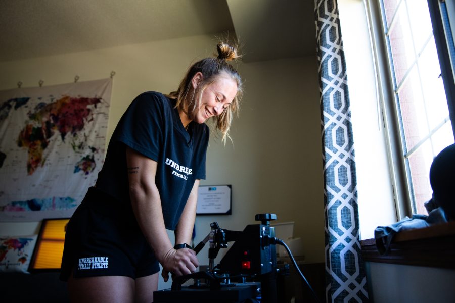 Iowa rower Jaecee Hall presses down on the heat press at her apartment in Iowa City on Sunday, June 19, 2022.