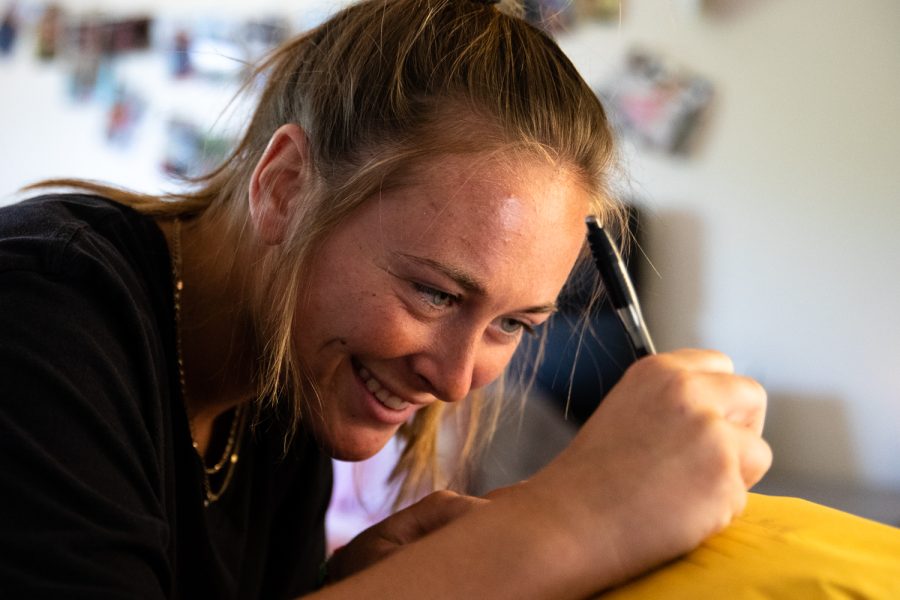 Iowa rower Jaecee Hall writes an address onto the package at her apartment in Iowa City on Sunday, June 19, 2022.