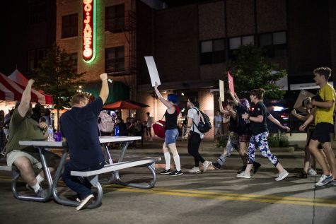 Downtown Block Party attendees cheer for protesters during “Night of Rage,” an abortion-rights protest, in Iowa City on Saturday, June 25, 2022. The protest started at the Pentacrest with speakers, then, protesters marched through Iowa City.