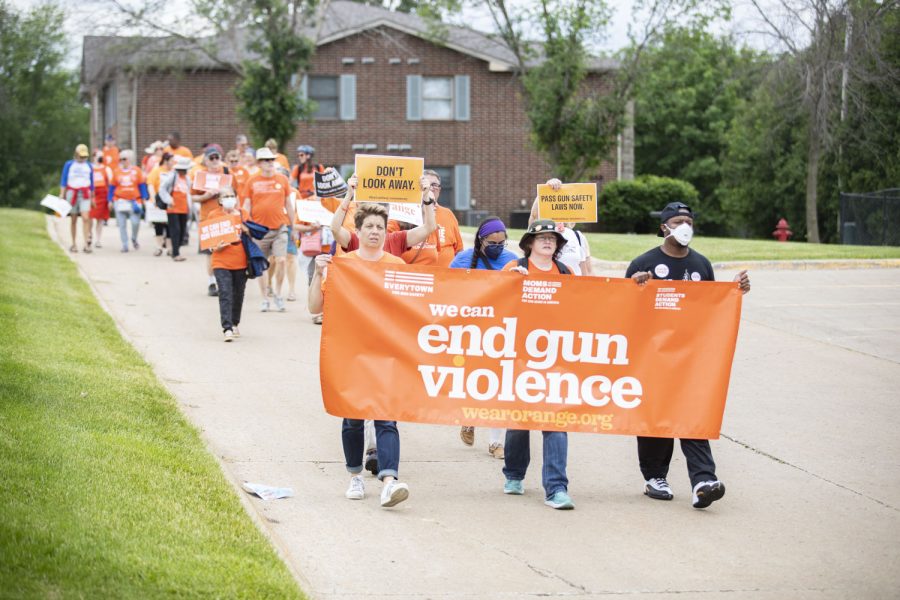 Attendees perform a peace walk during a “Wear Orange” community gathering, an event organized to honor victims and survivors of gun violence in an effort to end gun violence, at Wetherby Park in Iowa City on Saturday, June 4, 2022.