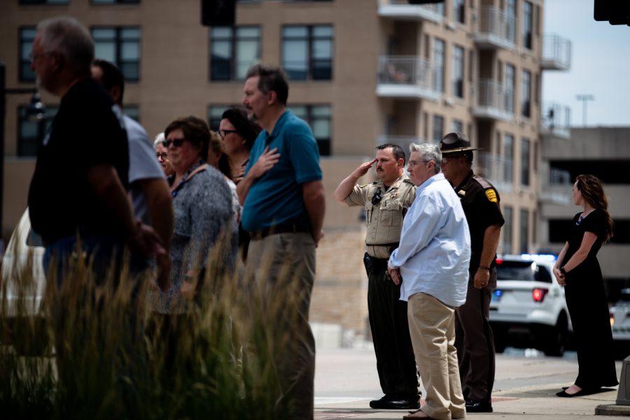 Community members watch a funeral procession for Coralville Police Sgt. John Williams on Burlington St. in Iowa City.