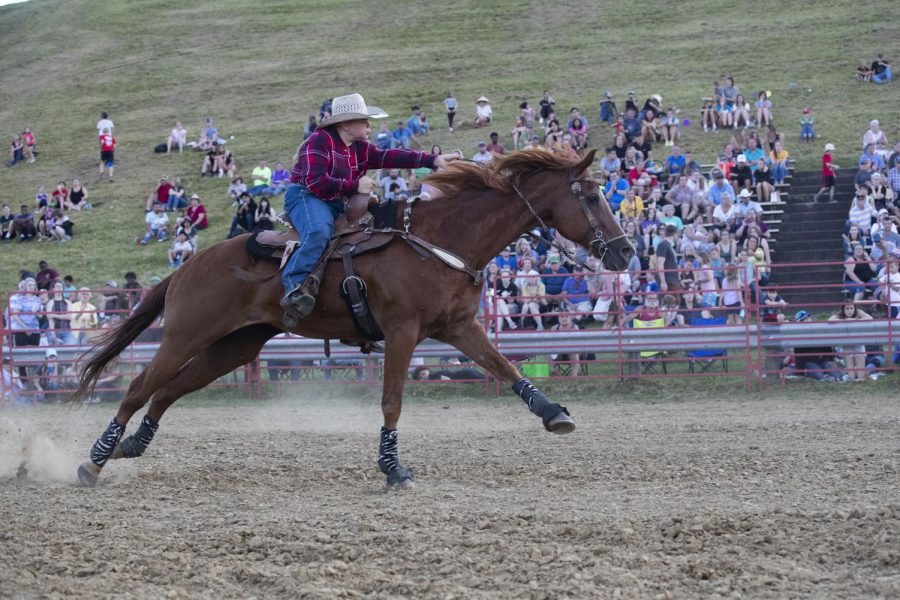 Ellie Evans rides her horse down the ring during the Sandburr Family Youth Rodeo at the Johnson County Fairgrounds in Iowa City on Wednesday, July 27, 2022.