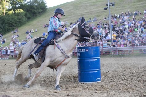 Lydia Franzenburg rides around the barrel during the Sandburr Family Youth Rodeo at the Johnson County Fairgrounds in Iowa City on Wednesday, July 27, 2022.