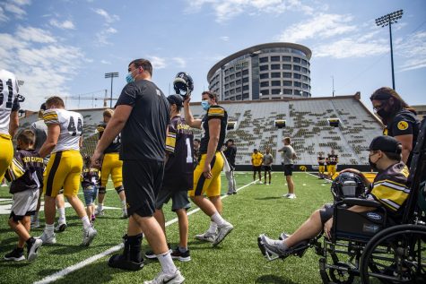 Iowa walks onto the field with the 2022 kid captains during Iowa football’s Kids’ Day at Kinnick in Iowa City on Saturday, Aug. 13, 2022. Iowa introduced its 2022 kid captains before the team practiced in front of fans.