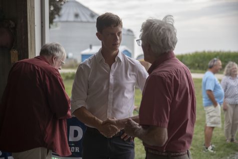 Iowa State Auditor Rob Sand shakes hands with a supporter during the Kinney Summer BBQ Bash at the Kinney Family Farm in Oxford, Iowa on Saturday, Aug. 27, 2022. Democratic candidate Kevin Kinney, D-Iowa, is running for Iowa Senate, District 39.
