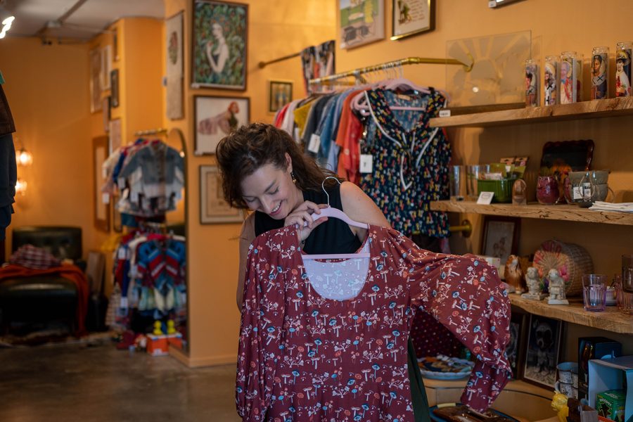 K. Fox, the owner of Eightfold Fox, describes a piece of clothing at Trunk Thrift Store in Iowa City on Friday, Aug. 26, 2022.