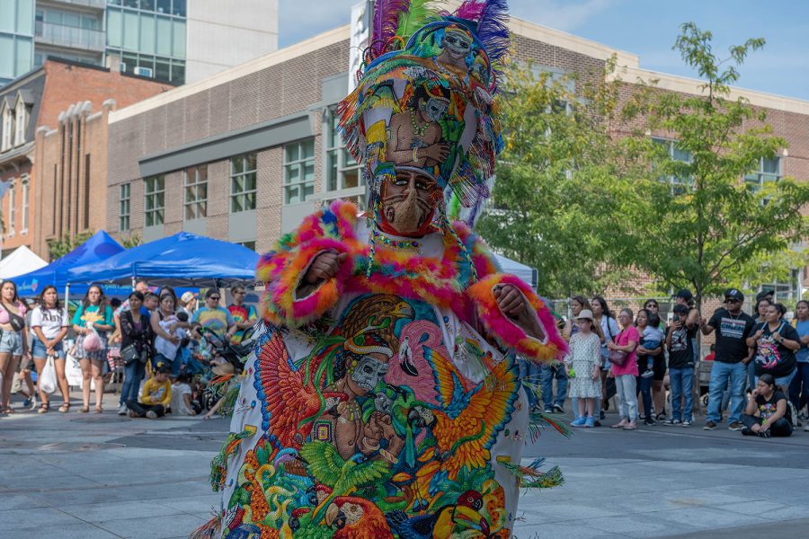 A performer at Iowa City’s Latino Festive changes attire in the Pedestrian Mall on Saturday, Aug. 27, 2022.