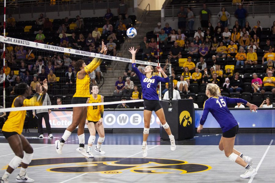 Northern Iowa setter Tayler Elden tips the ball over the net while middle hitter Amiya Jones jumps up to block during a volleyball match between Iowa and Northern Iowa at Xtream Arena in Coralville on Saturday, Sept. 17, 2022. The Hawkeyes defeated the Panthers 3-0.