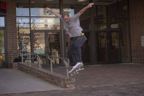Logan White,18, jumps off the rail in front of the Old Capital Mall on Sept. 19, 2022.