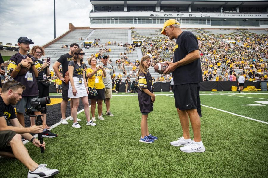 Kid captain Audrey Schneller speaks with head coach Kirk Ferentz during Iowa football’s Kids’ Day at Kinnick in Iowa City on Saturday, Aug. 13, 2022. 
