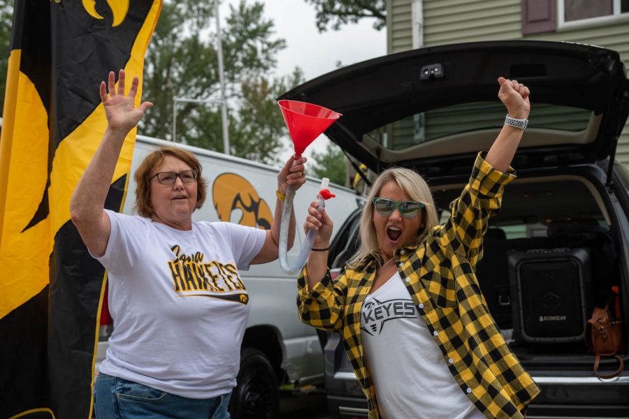 Hawkeye fans Sue Lakose and Autumn Shacklett pose with beer bong at a tailgate in Iowa City, Iowa, on Saturday, Sept. 10, 2022, for the Iowa vs. Iowa State football game.