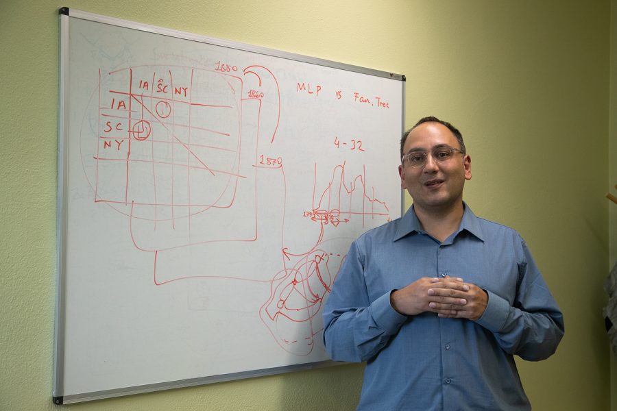Assistant Professor Caglar Koylu poses in front of a whiteboard mapping out part of his research on Friday, Sept. 23, 2022.
