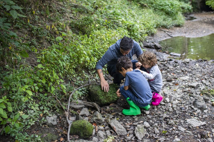 V, Emmons, and Celso look for bugs under a rock in a stream near the Fixmer-Oraiz home in Iowa City on Oct. 5. Natalie said despite V’s chaotic schedule, they always make time for their children. “As busy as V gets with work and this campaign, V puts it all aside,” Natalie said. “V will always make time for dinner, for play, for bath time.”