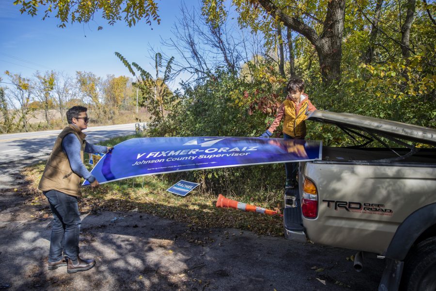 V Fixmer-Oraiz and their son, Emmons Fixmer-Oraiz, 7, take a campaign sign out of their truck to place in a supporter’s yard on Oct. 15. V said Emmons has been more interested in the election process because of V’s candidacy. “I don’t want [Emmons] to grow up railing against one side or the other,” the Iowa City resident of about a decade said. “I want him to see what it is for what it is, and understand at least the breadth of it if not the depth of it.”