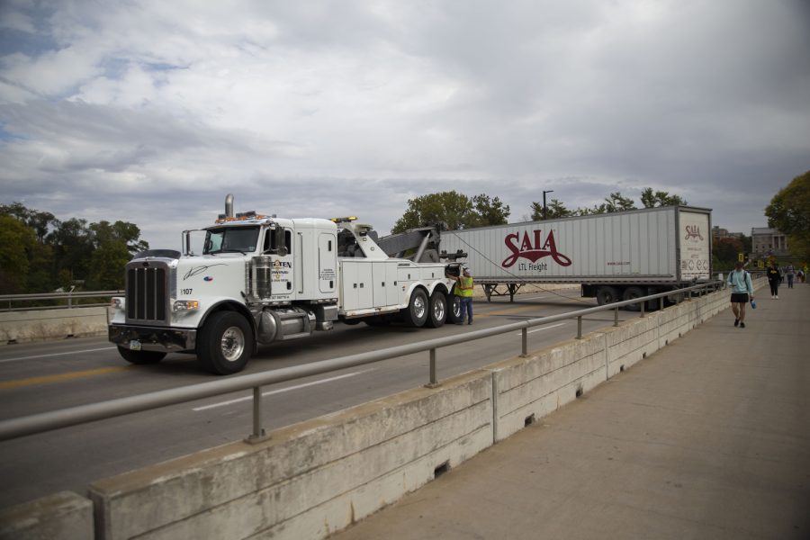 A tow truck pulls a freight after a semi-truck got stuck on the Iowa Avenue bridge on Wednesday, Oct. 5, 2022.