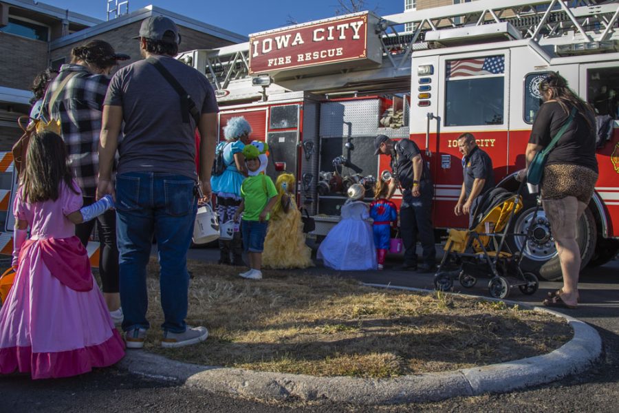 Families gather to take a look inside the Iowa City fire truck at Robert A. Lee Recreational Center on Friday, Oct. 21, 2022. The center held a sensory friendly Halloween event where games and food were available for kids. 