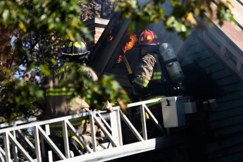 Firefighters attempt to extinguish a fire on Woodlawn Avenue in Iowa City on Sunday, Oct. 22, 2022. More than five Iowa City Fire Department trucks arrived to the scene around 9 a.m.