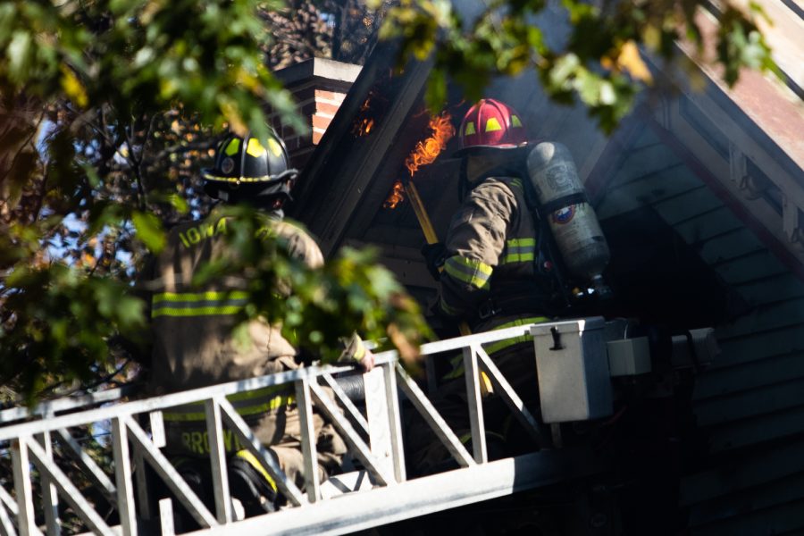 Firefighters attempt to extinguish a fire on Woodlawn Avenue in Iowa City on Sunday, Oct. 22, 2022. More than five Iowa City Fire Department trucks arrived to the scene around 9 a.m.