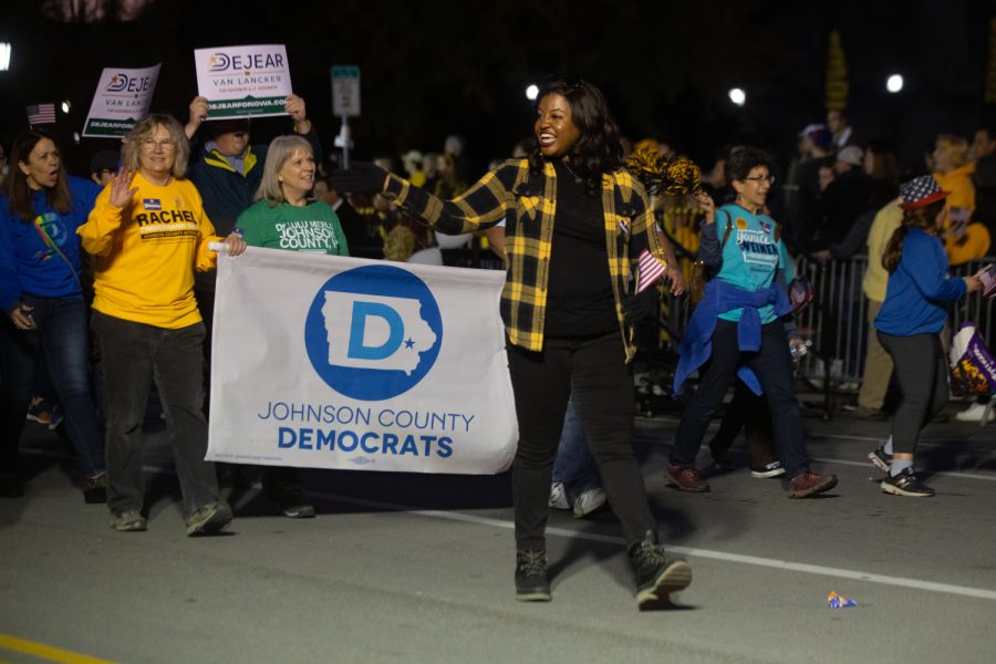 Democratic candidate for Iowa governor Deidre DeJear waves to parade goers during the University of Iowa Homecoming Parade and Pep Rally in Iowa City on Friday, Oct. 28, 2022.