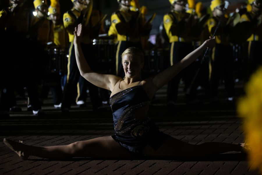 Golden girl Ella McDaniel does the splits while performing at the University of Iowa Homecoming Parade and Pep Rally in Iowa City on Friday, Oct. 28, 2022.