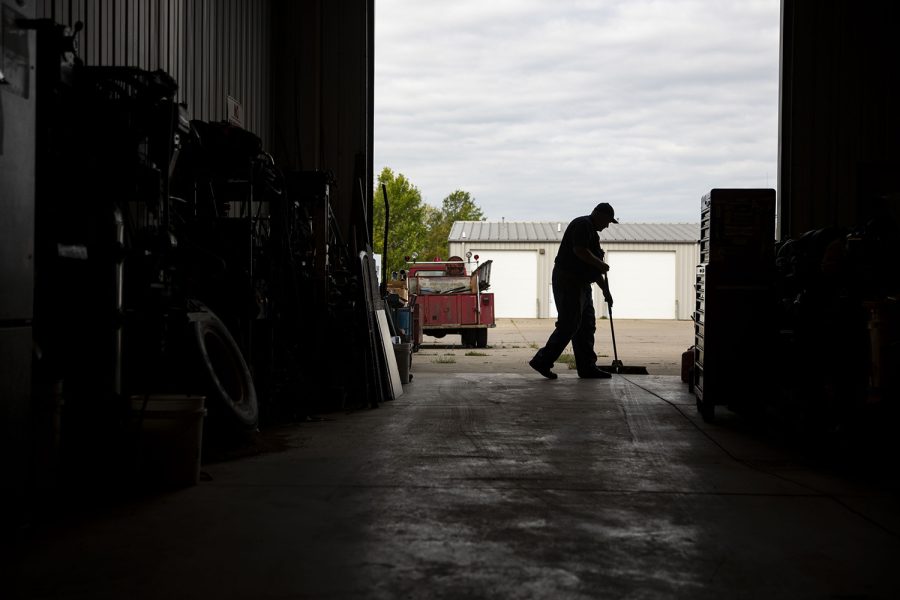 After servicing a vehicle, Phil sweeps out his shop to end his workday. Phil sees the value in schools placing value in careers outside of college and plans to invest a portion of his salary to schools in Johnson county who have agriculture or Future Farmers of America (FFA) programs, so students get the opportunity to experience agriculture and trades.  (Ayrton Breckenridge/The Daily Iowan)