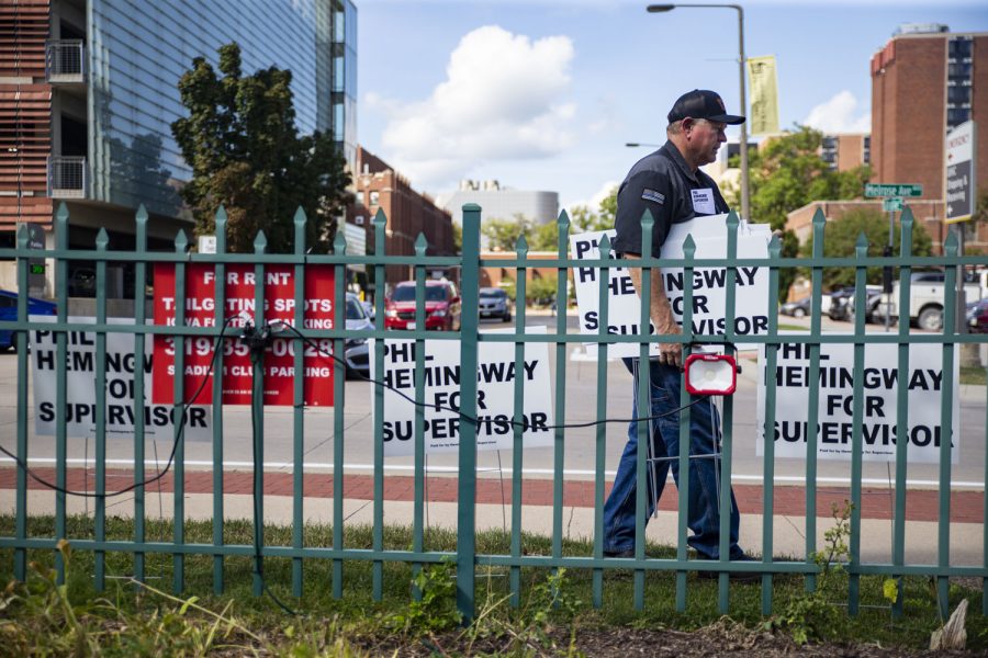 Phil sets up signs in front of the Johnson County Republican headquarters in Iowa City for a campaign event before Clash at Kinnick on Friday, Aug. 26, 2022. (Ayrton Breckenridge/The Daily Iowan)