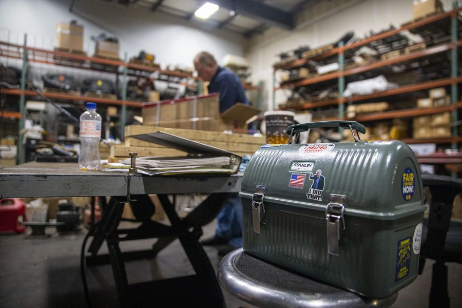 Phil’s lunch box covered with union stickers and a satirical Joe Biden sticker sits on a chair as Phil works at Greg's Lawn and Landscaping on Friday, Aug. 26, 2022. (Ayrton Breckenridge/The Daily Iowan)