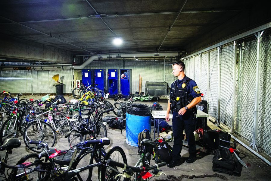 Iowa City police officer Jeffery Schmidt walks through a room containing evidence, personal goods, and bikes on Aug. 29, 2022.