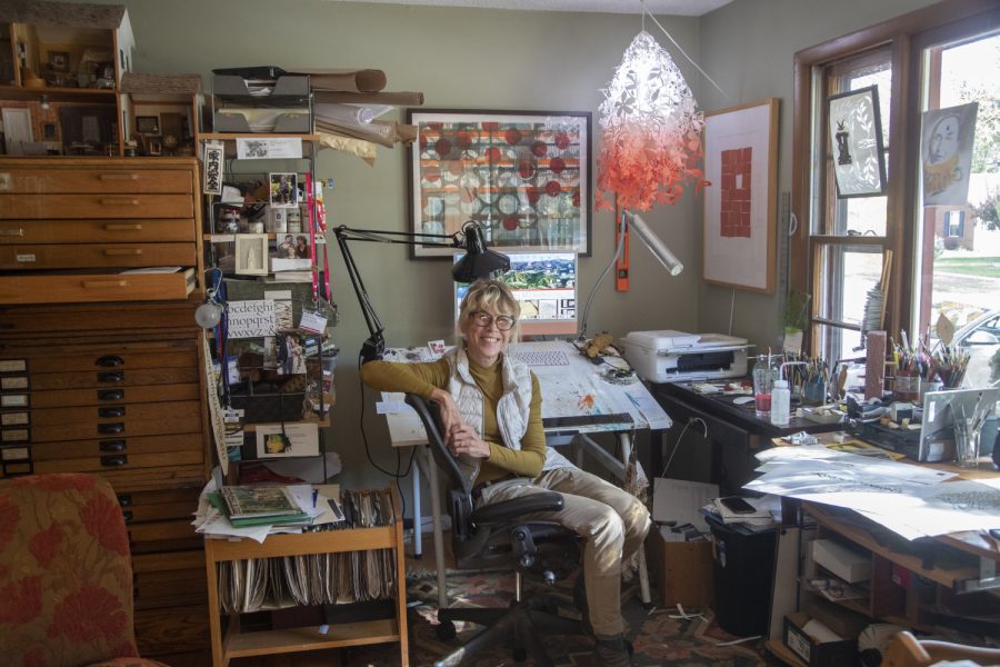 Cheryl Jacobsen, surrounded by supplies and her projects, in her workstation at her home studio, on Wednesday, Oct. 12, 2022. 