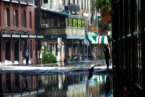 People stop to take photos of the flooded cobblestone on River Street Monday afternoon. Chatham Emergency Management Agency said while Hurricane Irma brought Savannah less debris that Hurricane Matthew, the flooding from the Irma has been worse.