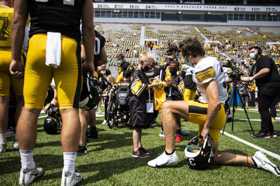 Kid+Captain+Carver+Meiners+waits+for+an+autograph+from+Iowa+defensive+back+Riley+Moss+during+Iowa+footballs+Kids+Day+at+Kinnick+in+Iowa+City+on+Aug.+13.