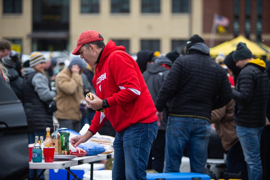 A Badgers fan grabs food at a tailgating lot in Iowa City on  Saturday, Nov. 12, 2022.