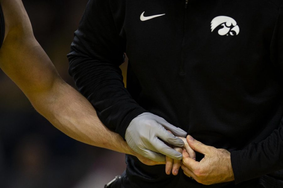 A medic checks Iowa’s 174-pound Drake Rhodes finger during a wrestling meet between Iowa and Cal Baptist at Carver-Hawkeye Arena on Sunday, Nov. 13, 2022. The Hawkeyes defeated the Lancers, 42-3. 