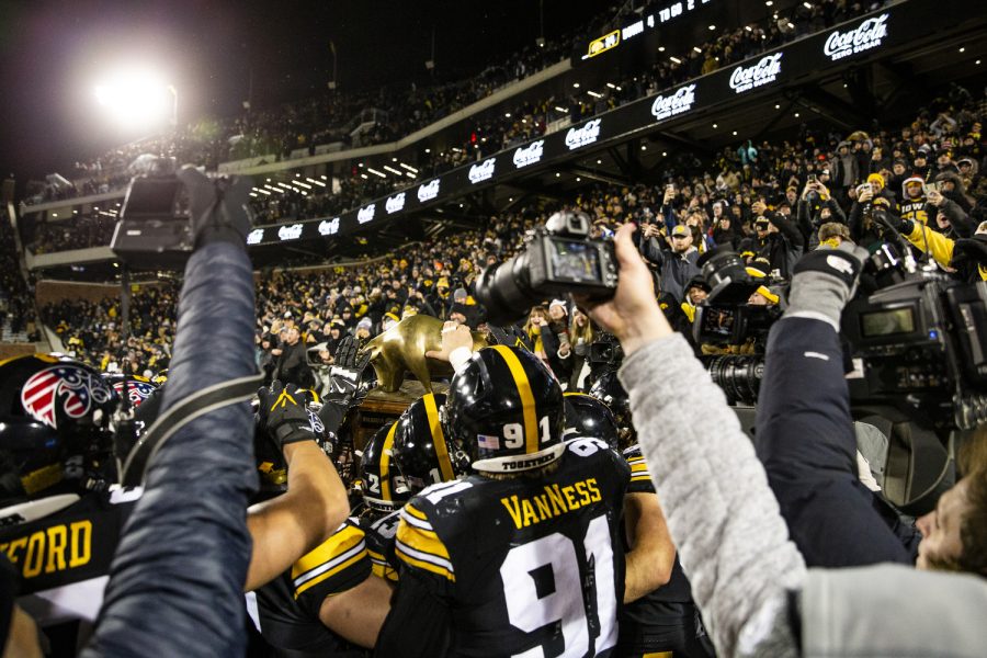 The Hawkeyes rush the Heartland Trophy during a football game between Iowa and Wisconsin at Kinnick Stadium in Iowa City on Saturday, Nov. 12, 2022. With the win, the Hawkeyes improved their series record against the Badgers to 49-45. The Hawkeyes, defeated the Badgers, 24-10.