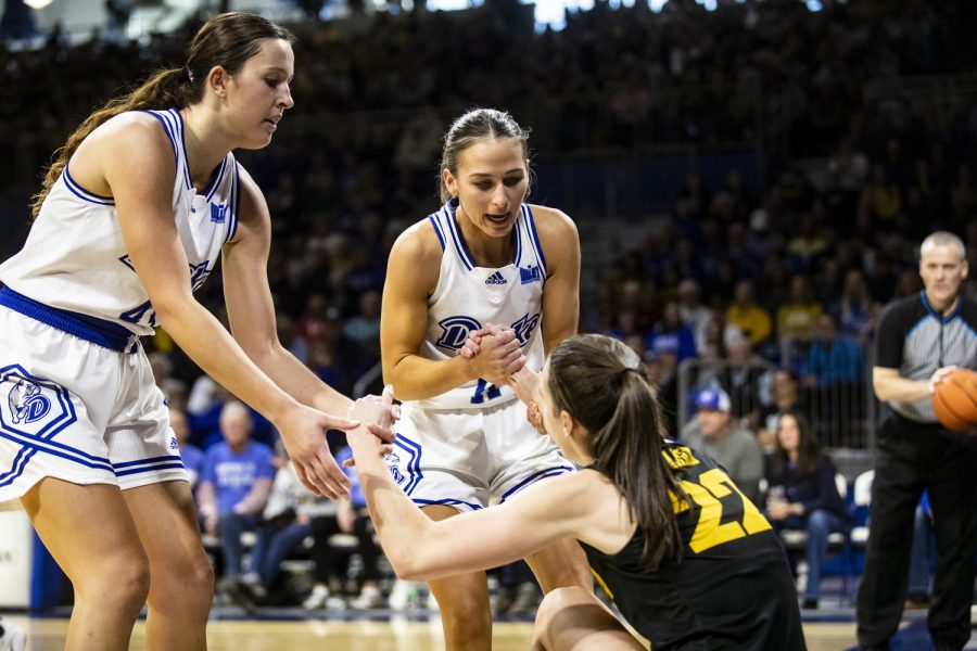 Drake forward Grace Berg and guard Megan Meyer help up Iowa guard Caitlin Clark during a basketball game between Iowa and Drake at the Knapp Center in Des Moines, Iowa, on Sunday, Nov. 13, 2022. The Hawkeyes defeated the Bulldogs in overtime, 92-86. 