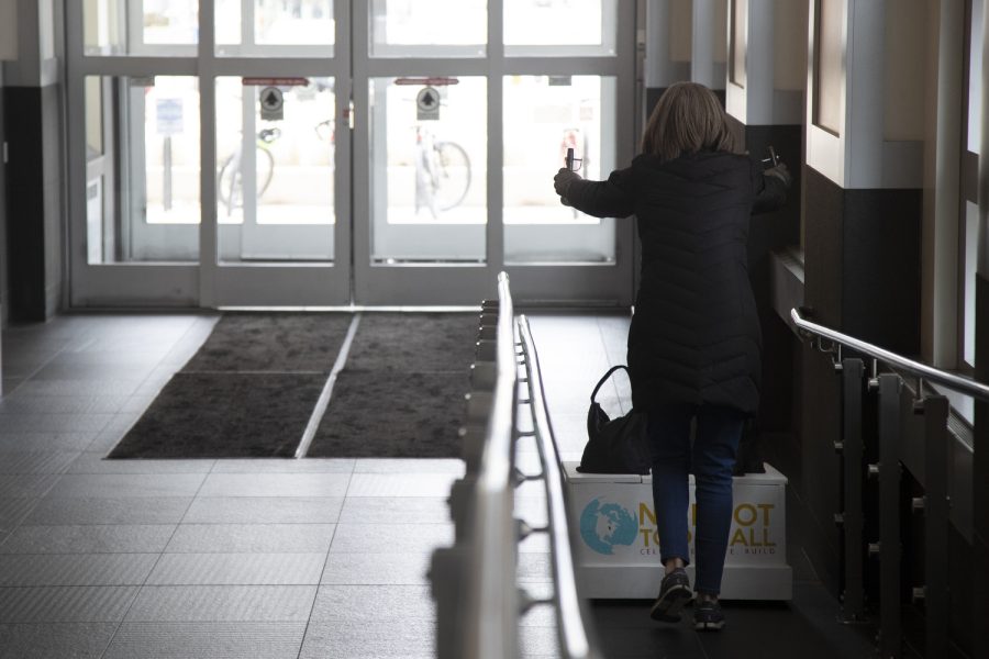 Krista Porter moves the stand of the No Foot Too Small art sculpture from the Iowa City Public Library Nov. 18, 2022.