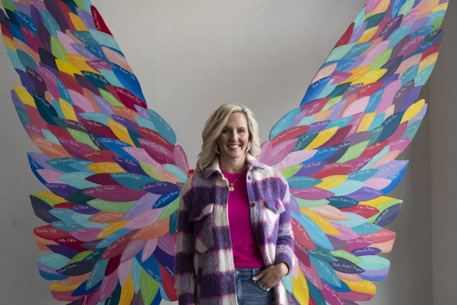 Robin Boudreau, one of the co-founders of the No Foot Too Small project poses in front of the art sculpture at the Hyatt Regency in Coralville Iowa Nov. 18, 2022. The wings raise awareness for pregnancy and infant loss; each feather being someone lost.