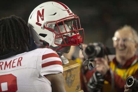 Nebraska quarterback Logan Smothers carries the Heroes trophy after a football game between Iowa and the Nebraska at Kinnick Stadium on November 25, 2022.  The Cornhuskers defeated the Hawkeyes, 24-17.