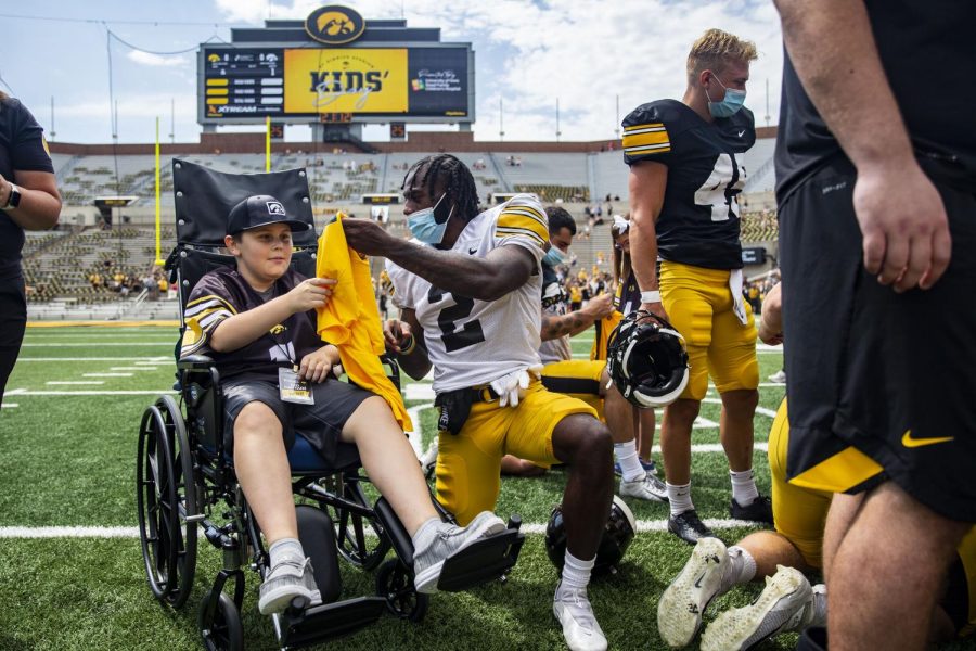 Kid captain Dylan McGivern grabs a signed shirt from Iowa defensive back Terry Roberts during Iowa football’s Kids’ Day at Kinnick in Iowa City on Saturday, Aug. 13, 2022.
