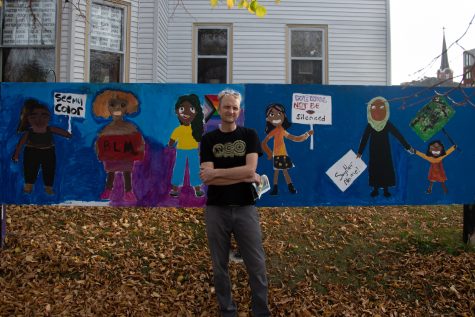Executive Director of Public Space One John Engelbrecht poses for a photo in front of the mural outside of Public Space One North Thursday, Nov. 3, 2022.