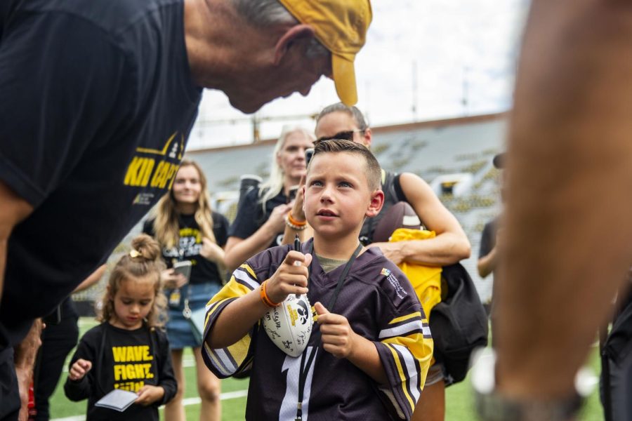 Kid captain Tate Manahl speaks with head coach Kirk Ferentz during Iowa football’s Kids’ Day at Kinnick in Iowa City on Saturday, Aug. 13, 2022.  
