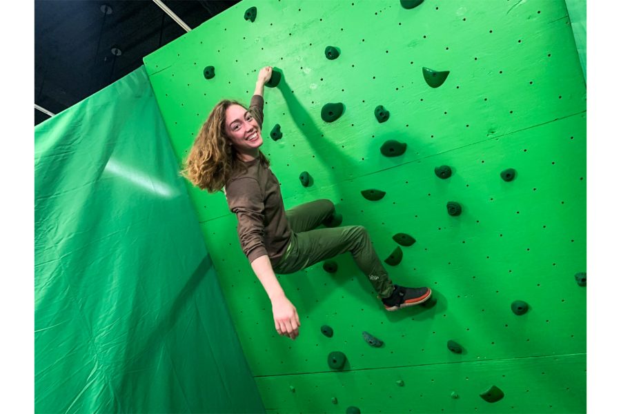 Ellen Oliver, an MFA dance student at the University of Iowa, poses for a portrait on a green screen rock climbing wall in the Old Art Museum on Wednesday, Nov. 9, 2022. Ellen’s research explores the intersections of rock climbing and dancing with digital arts. “My goals are to deepen my relationship with rock climbing and to learn how my rock climbing body can inform by dancing performing body,” said Oliver. Ellen hopes to create a touring dance performance in rock gyms within the future. 