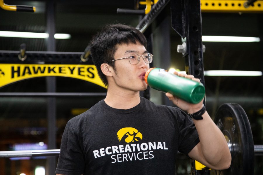 Iowa graduate Chinese student Muyun Lin takes a short water break between his workout at the Campus Recreation and Wellness Center in Iowa City on Tuesday, November 22, 2022.