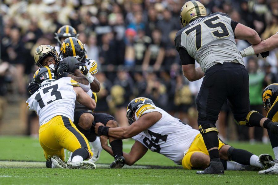 Purdue running back Dylan Downing (38) carries the ball as Iowa defensive end Joe Evans (13) tackles him during a football game between Iowa and Purdue at Ross–Ade Stadium in West Lafayette, Ind., on Saturday, Nov. 5, 2022. The Hawkeyes defeated the Boilermakers, 24-3.