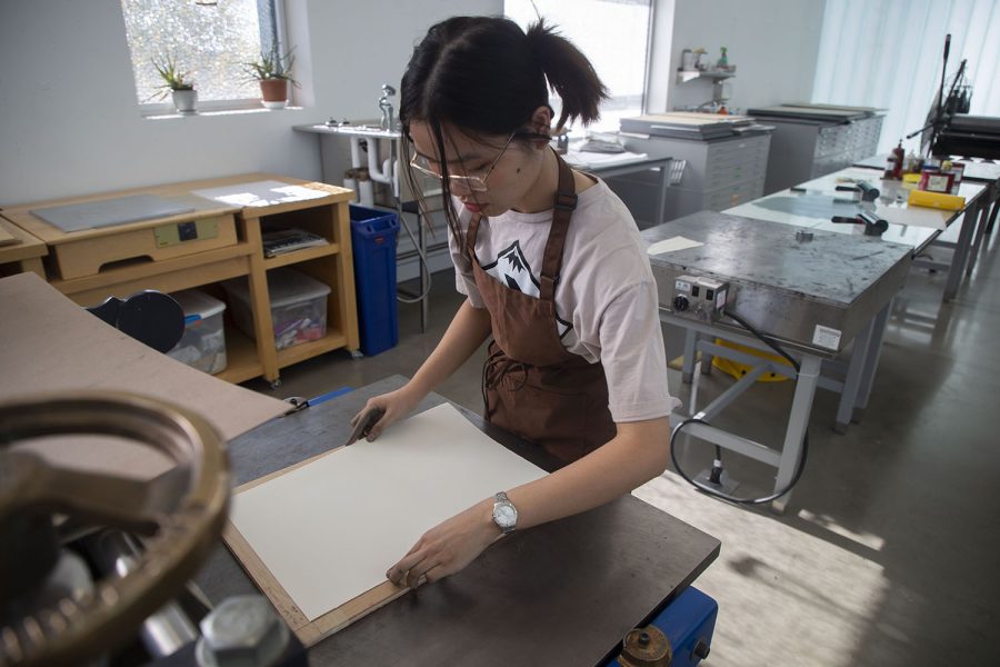University of Iowa junior June K lays paper on a woodcut at the Visual Arts Building in Iowa City on Oct. 17, 2022.