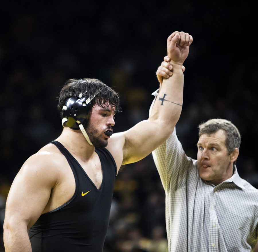 Iowa head coach Tom Brands holds up Iowa’s No. 5 285-pound Tony Cassioppi’s arm to celebrate a victory during a wrestling meet between No. 2 Iowa and No. 7 Iowa State at Carver-Hawkeye Arena in Iowa City on Sunday, Dec. 4, 2022. The Hawkeyes defeated the Cyclones, 18-15. 