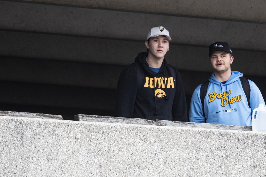 Spectators watch an emergency situation while the Iowa City Police Department was called to the Court Street parking ramp for what started as a welfare check in downtown Iowa City on Monday, Dec. 12, 2022. According to a UI Police affidavit, officers received a third-party report that a woman had been forced against her will to go to the bus station by her husband, who allegedly took her from a Cedar Rapids location on Sunday night. After police arrived, Cardale Hunter, 33, pulled out a gun and used the woman as a shield while holding her at gunpoint. According to the City of Iowa City press release, the situation was resolved after the man shot himself, but no other injuries have been reported. Hunter is in stable condition. Hunter is facing charges of second-degree kidnapping, possession of a firearm by a felon, going armed with intent, domestic abuse while displaying a weapon, and child endangerment, according to a UI police release.