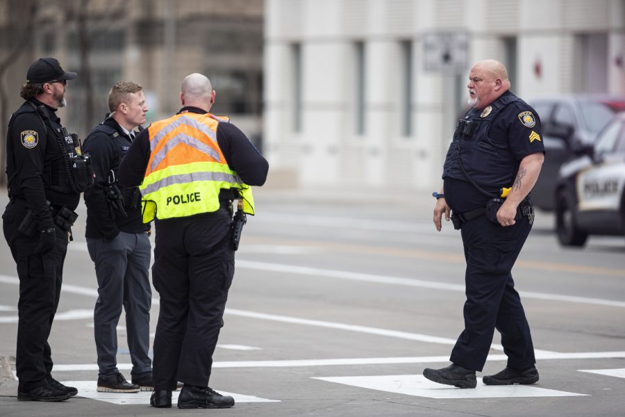 First responders communicate on the Burlington Street crosswalk after the Iowa City Police Department was called to the Court Street parking ramp for what started as a welfare check in downtown Iowa City on Monday, Dec. 12, 2022. According to a UI Police affidavit, officers received a third-party report that a woman had been forced against her will to go to the bus station by her husband, who allegedly took her from a Cedar Rapids location on Sunday night. After police arrived, Cardale Hunter, 33, pulled out a gun and used the woman as a shield while holding her at gunpoint. According to the City of Iowa City press release, the situation was resolved after the man shot himself, but no other injuries have been reported. Hunter is in stable condition. Hunter is facing charges of second-degree kidnapping, possession of a firearm by a felon, going armed with intent, domestic abuse while displaying a weapon, and child endangerment, according to a UI police release.