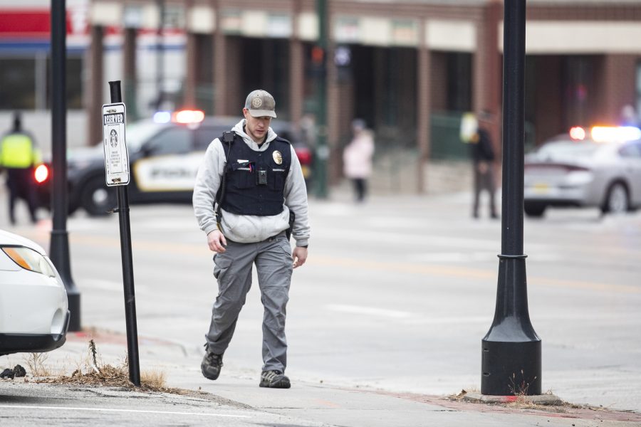 A police officer walks away from the parking ramp after the Iowa City Police Department was called to the Court Street parking ramp for what started as a welfare check in downtown Iowa City on Monday, Dec. 12, 2022. According to a UI Police affidavit, officers received a third-party report that a woman had been forced against her will to go to the bus station by her husband, who allegedly took her from a Cedar Rapids location on Sunday night. After police arrived, Cardale Hunter, 33, pulled out a gun and used the woman as a shield while holding her at gunpoint. According to the City of Iowa City press release, the situation was resolved after the man shot himself, but no other injuries have been reported. Hunter is in stable condition. Hunter is facing charges of second-degree kidnapping, possession of a firearm by a felon, going armed with intent, domestic abuse while displaying a weapon, and child endangerment, according to a UI police release.